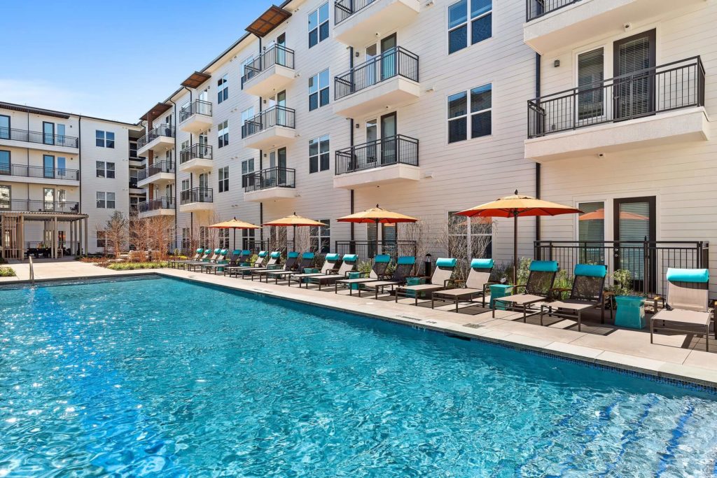 Daytime shot of resort-style pool with lounge seating and umbrellas