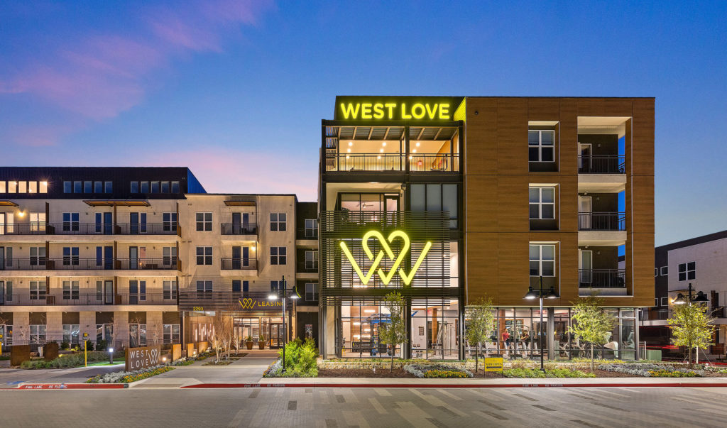 West Love leasing and community building with decorative landscaping and signage