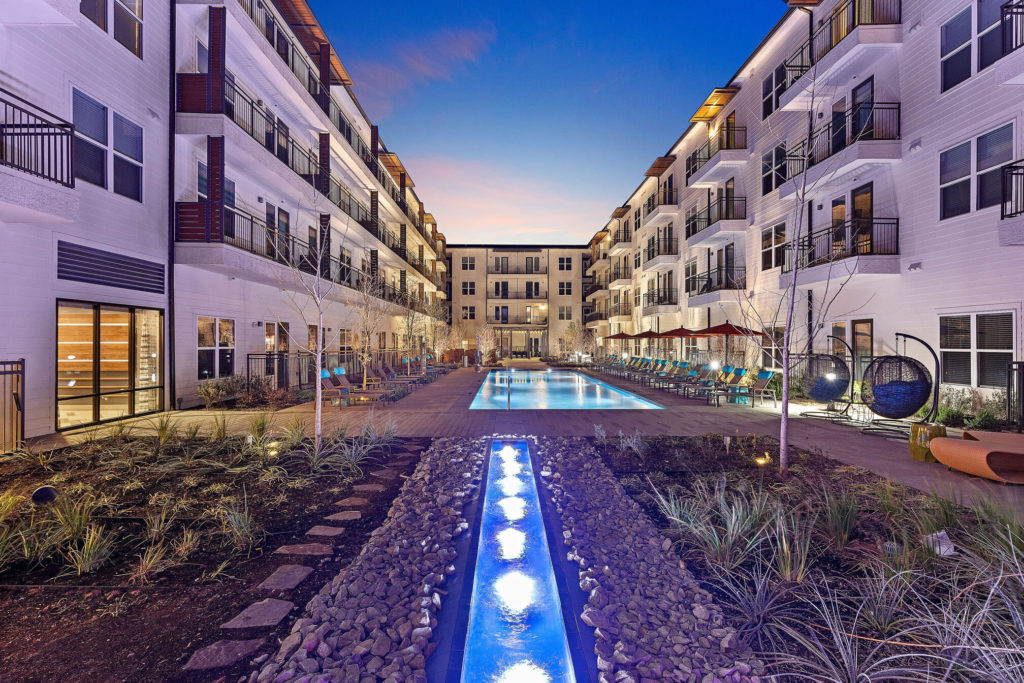 Pool courtyard with decorative fountains, landscaping, resort-like pool and variety of lounge seating